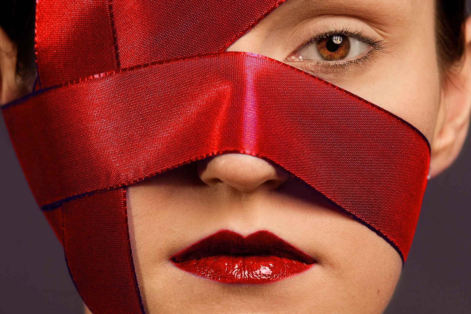 Beauty-Nahaufnahme mit rotem Stoffband und roten Lippen
