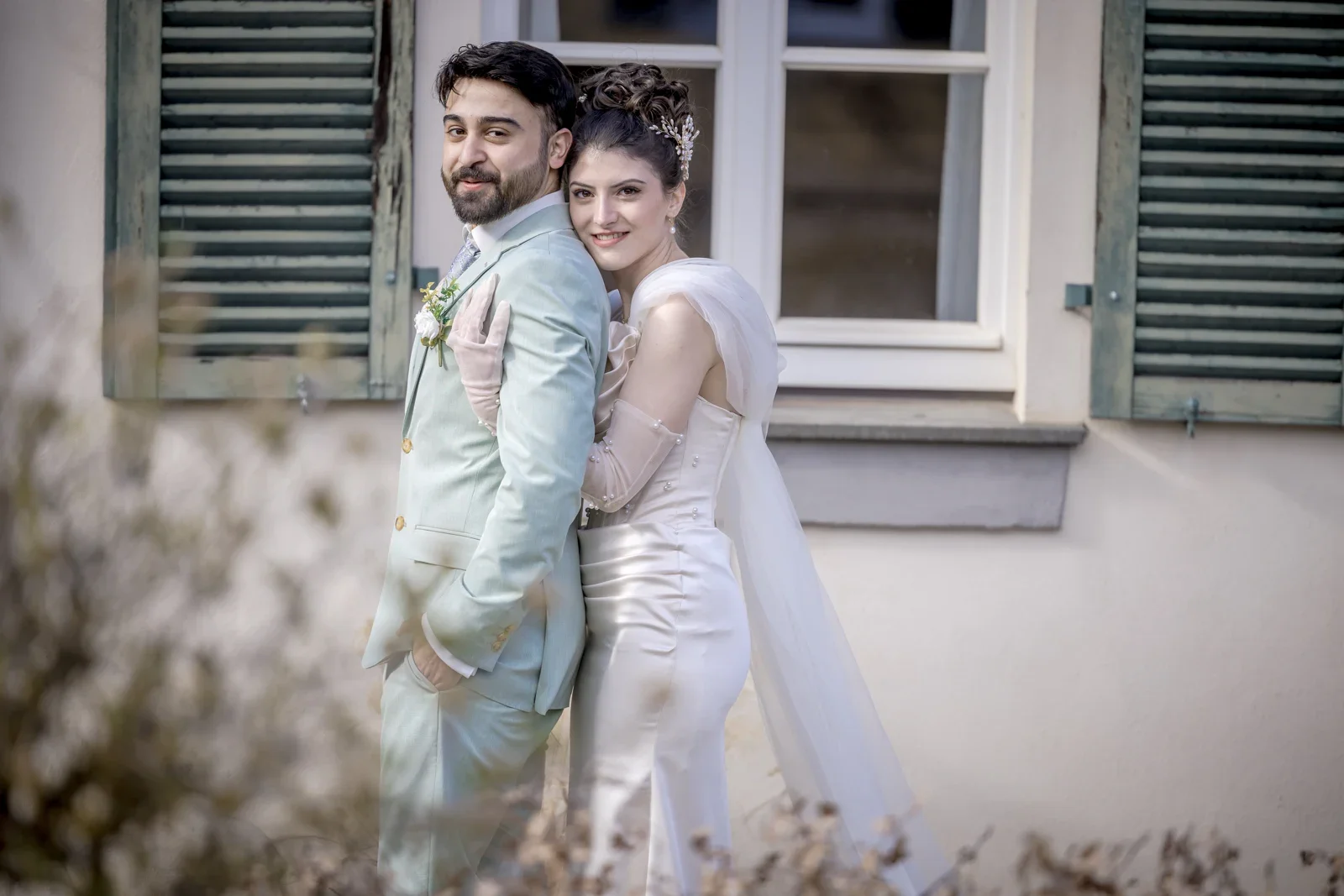 Nah beieinander vor den Fensterläden – Hochzeit von Celina und Mümün