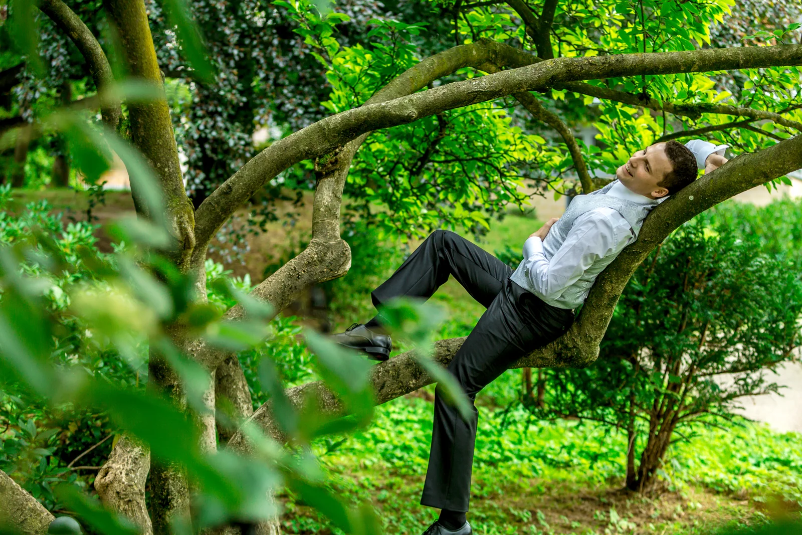 Martin mit einer spielerischen Pose im Baum – Hochzeit von Antje und Martin auf dem Schlossberg in Sonneberg