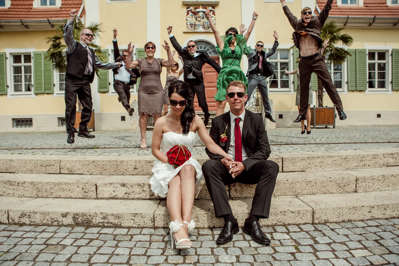 Ein ausgelassenes Gruppenfoto vor dem Schlösschen – Hochzeitsreportage von Jan und Sabrina