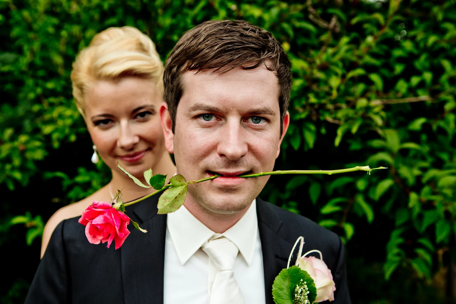 Tobi mit einer Rose und Romy im Hintergrund – Hochzeitsreportage von Romy und Tobi