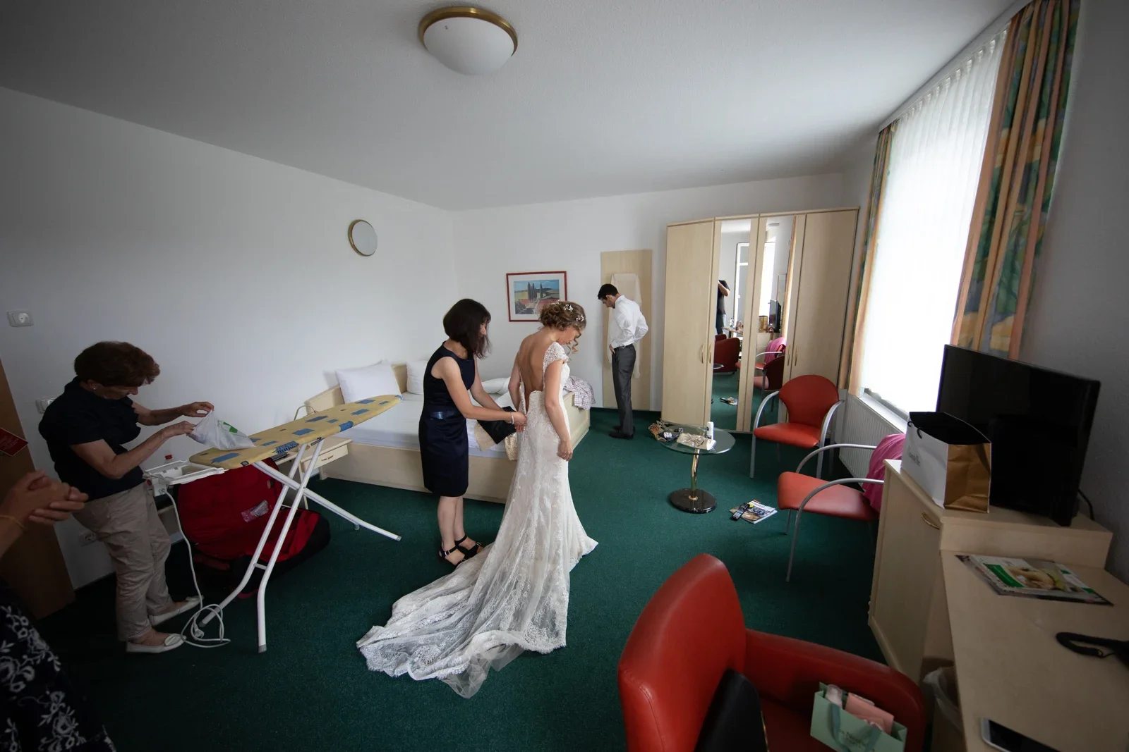 Gemeinsam wird Sylvia beim Anziehen geholfen – Hochzeit von Sylvia und Danny in Bad Salzungen