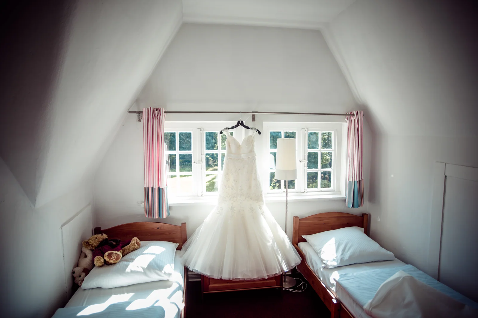 Das Hochzeitskleid am Fenster des Zimmers – Hochzeitsreportage von Basti und Debbi