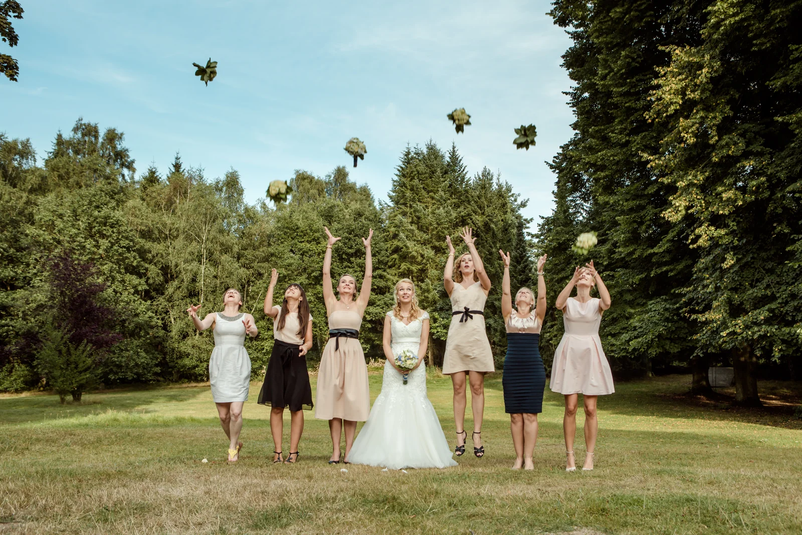 Blumensträuße fliegen beim Gruppenfoto in die Luft – Hochzeitsreportage von Basti und Debbi