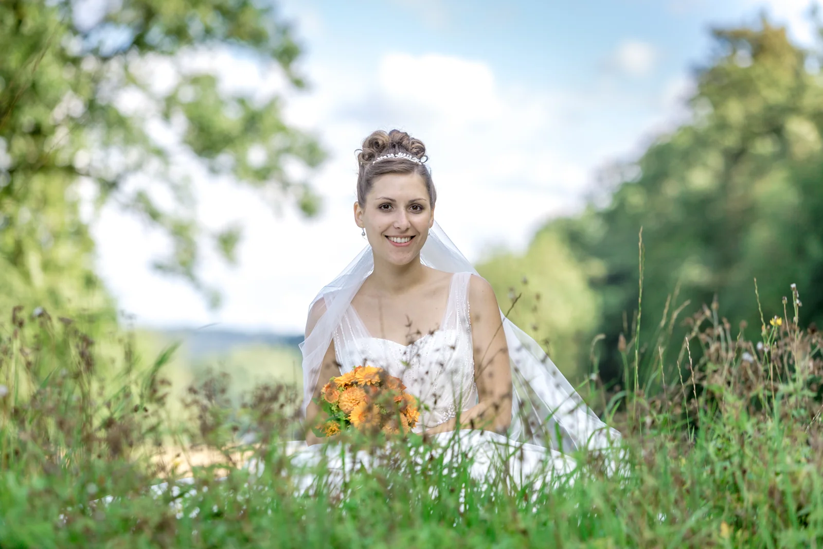 Veronika auf der Wiese mit ihrem Brautstrauß – Hochzeitsreportage von Veronika und Andreas