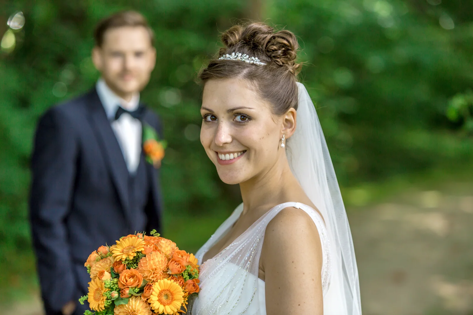 Veronika mit Andreas im Hintergrund – Hochzeitsreportage von Veronika und Andreas