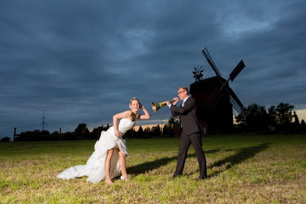 Ein lustiger Moment mit dem Horn vor der Windmühle – Hochzeitsreportage von Delf Zeh