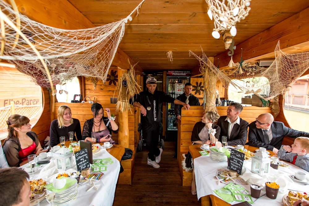 Die Hochzeitsgesellschaft sitzt an der Tafel auf dem Floß – Hochzeitsreportage von Maik und Doreen