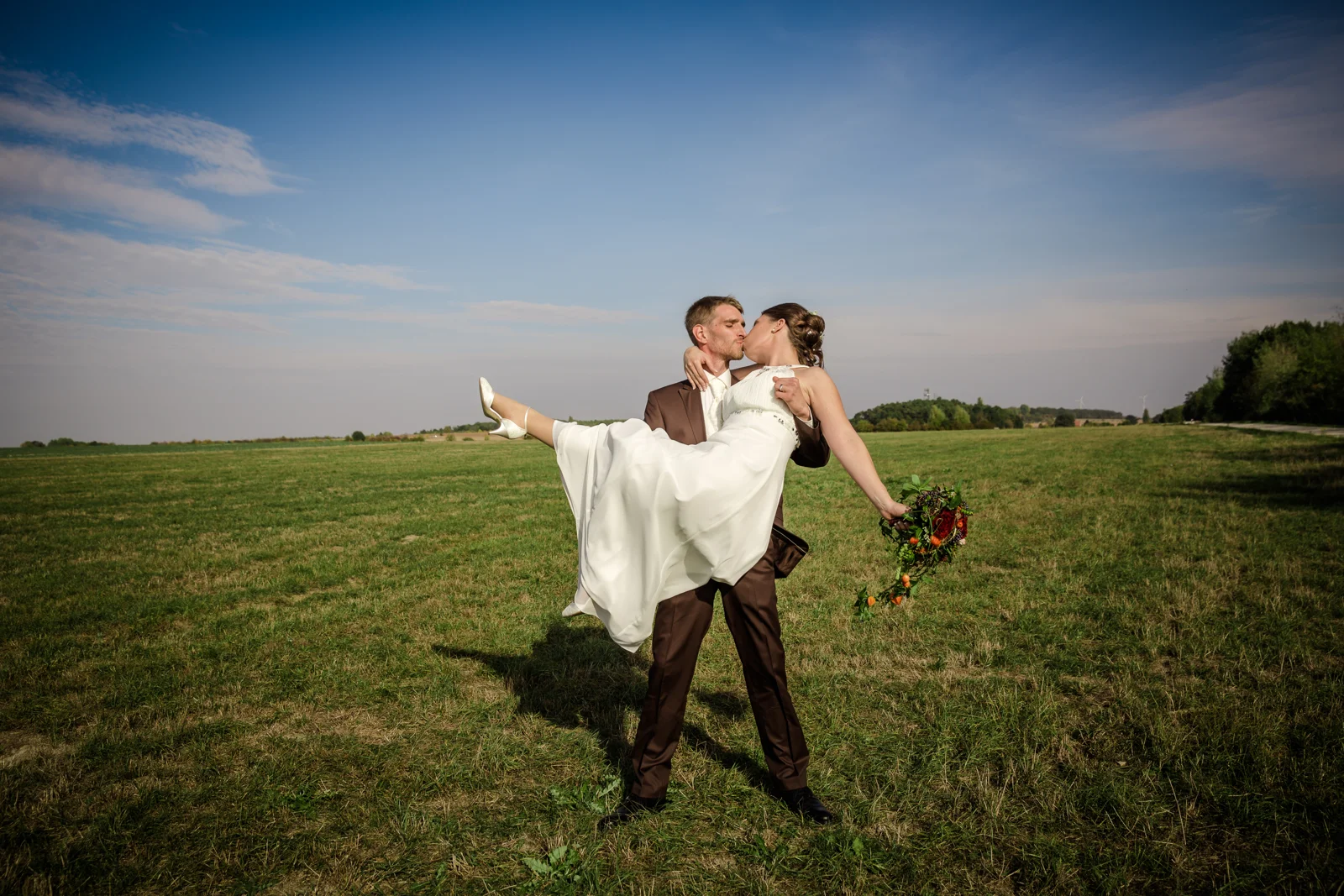 Daniel trägt Katharina über die Wiese – Hochzeit von Daniel und Katharina in Emskirchen – Schloss Brunn
