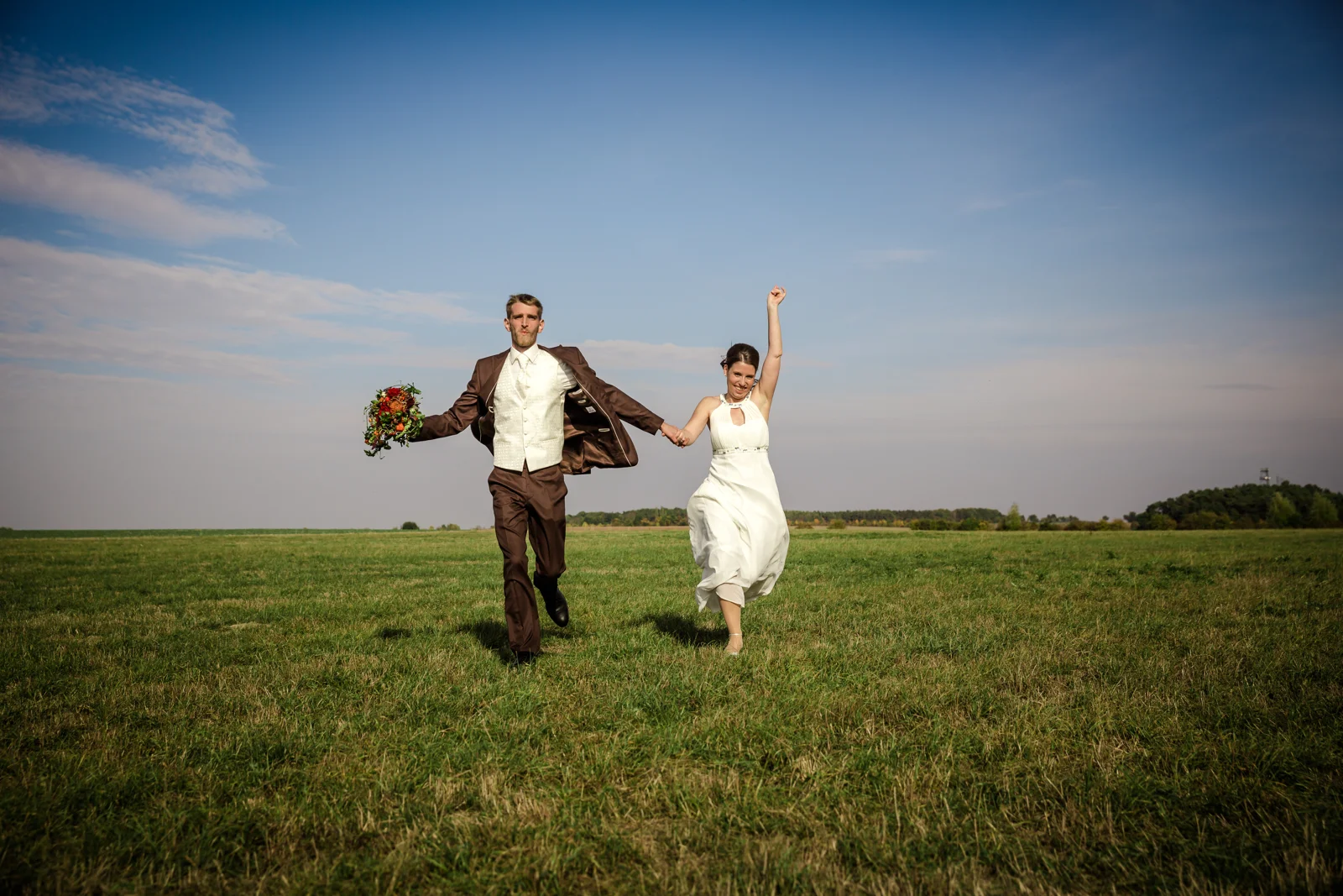 Hand in Hand mit einem Sprung über die Wiese – Hochzeit von Daniel und Katharina in Emskirchen – Schloss Brunn