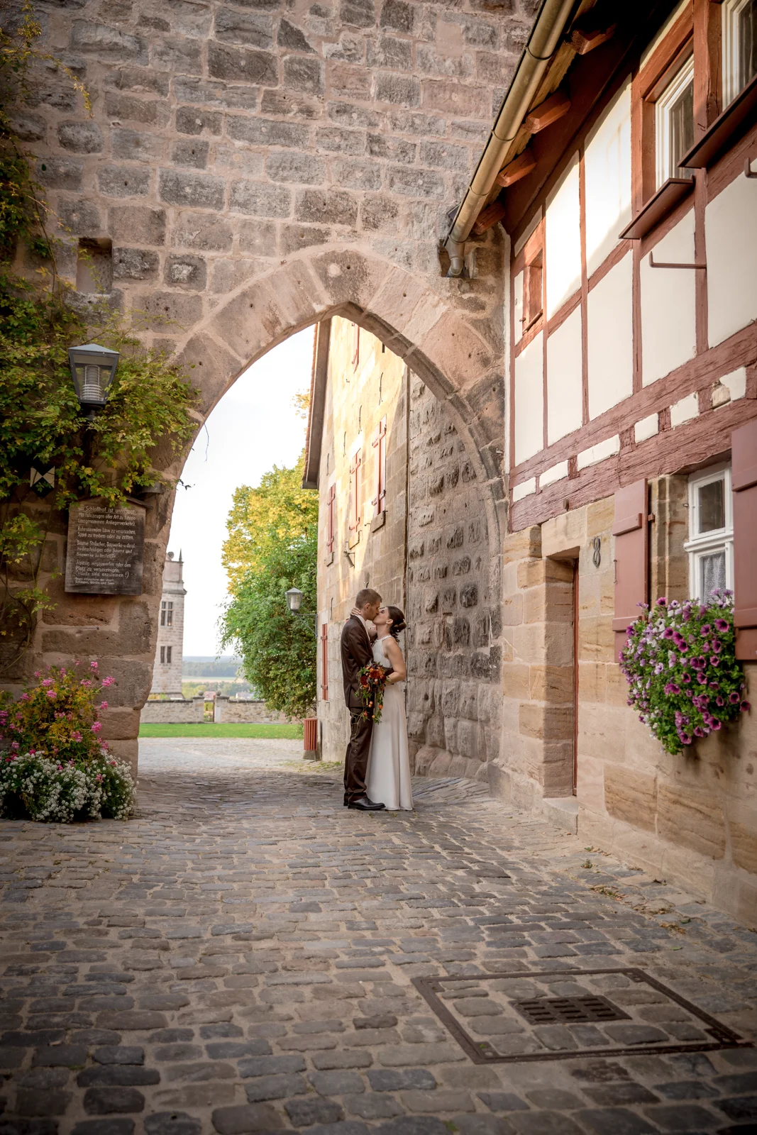 Ein vertrauter Moment im Torbogen – Hochzeit von Daniel und Katharina in Emskirchen – Schloss Brunn
