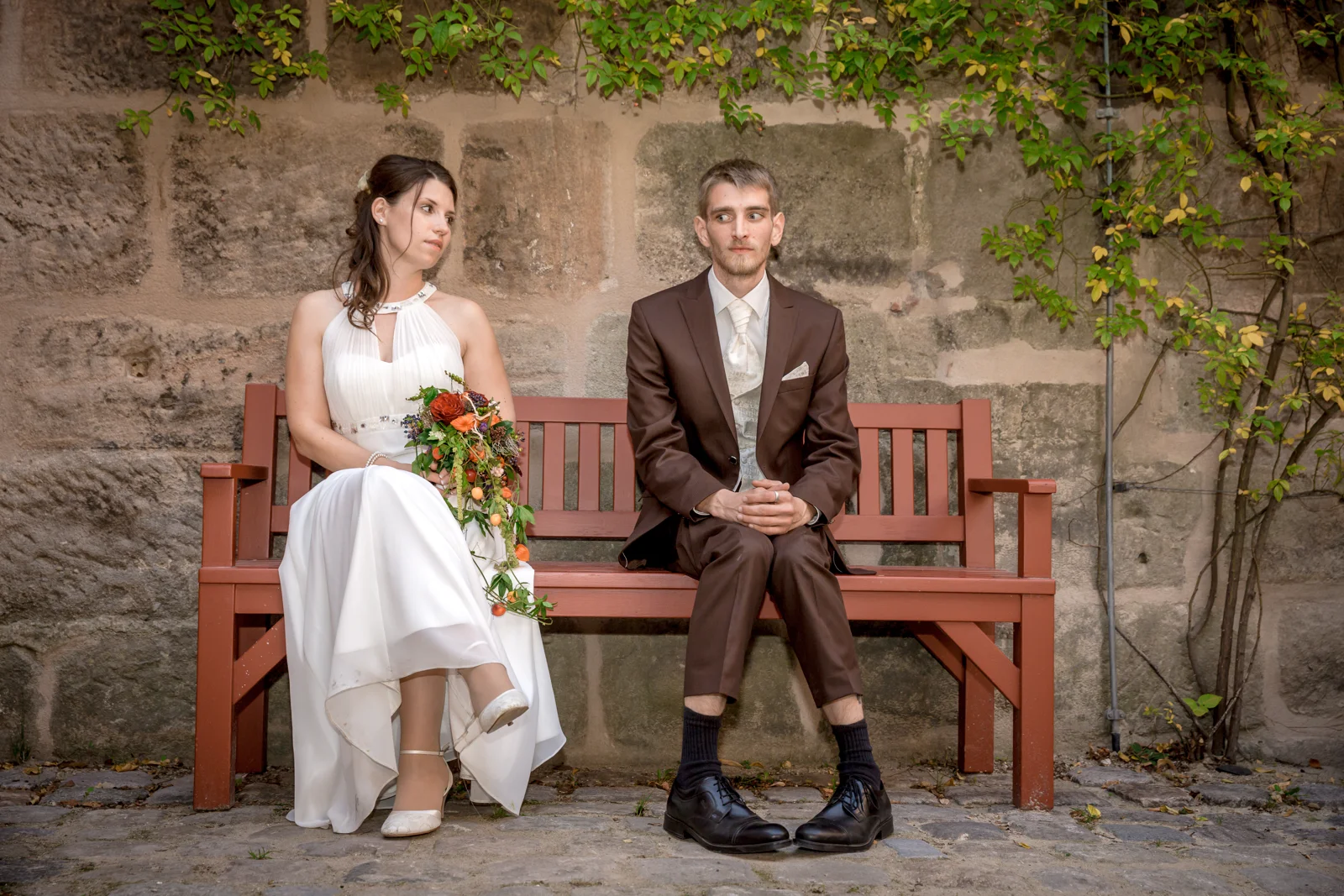 Eine gemeinsame Pause auf der roten Bank – Hochzeit von Daniel und Katharina in Emskirchen – Schloss Brunn