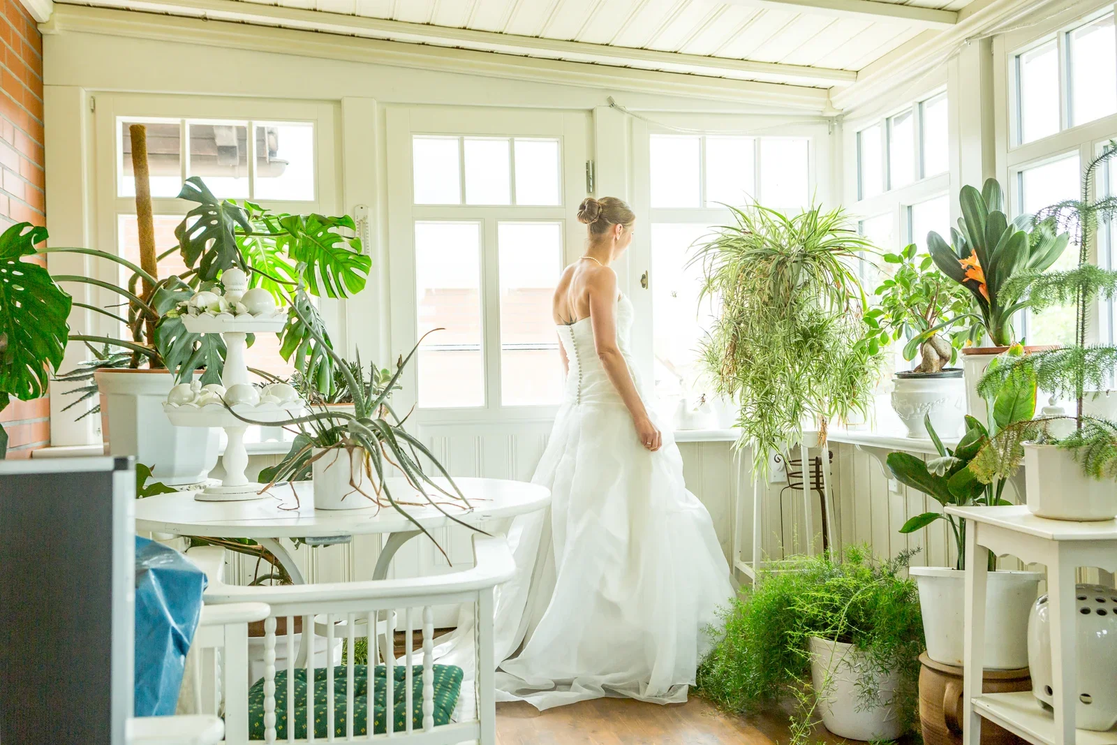Viktoria zwischen den Pflanzen am Fenster – Hochzeit von Viktoria und Sebastian