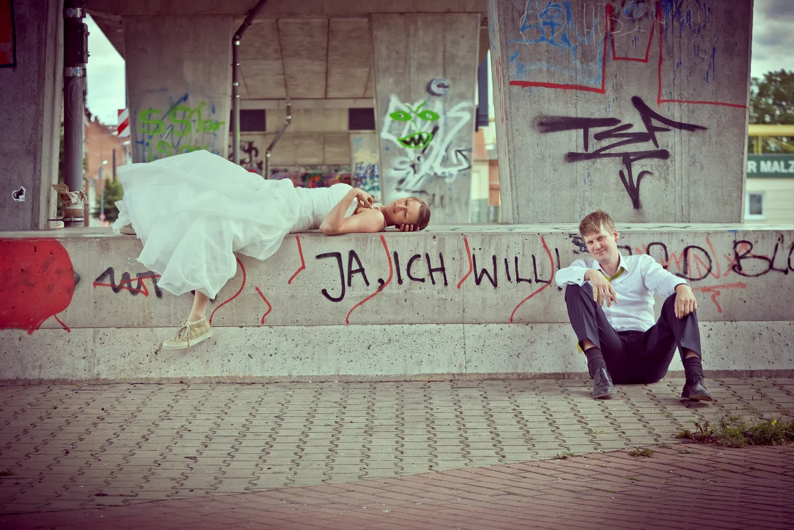 Ein verspieltes Paarbild vor der Graffitiwand – Hochzeit von Viktoria und Sebastian