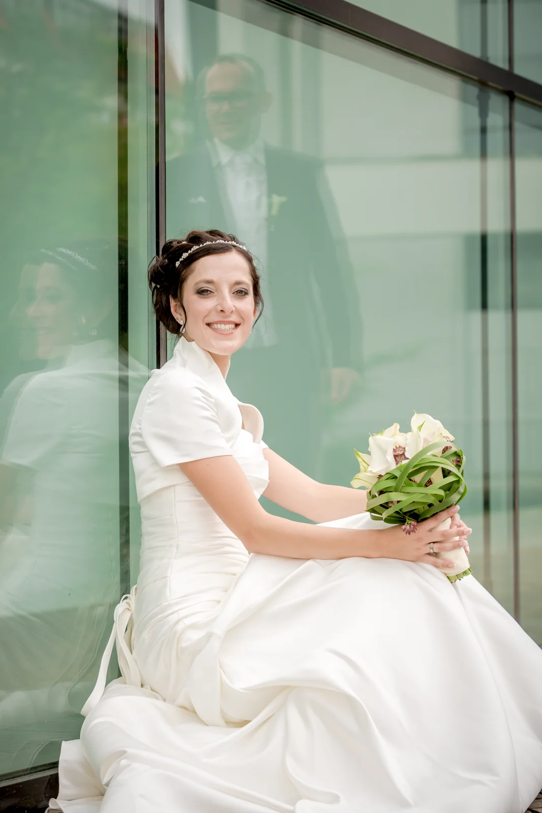 Lydia an der Glasfassade des Theaters – Hochzeit von Lydia und Christian in Erfurt