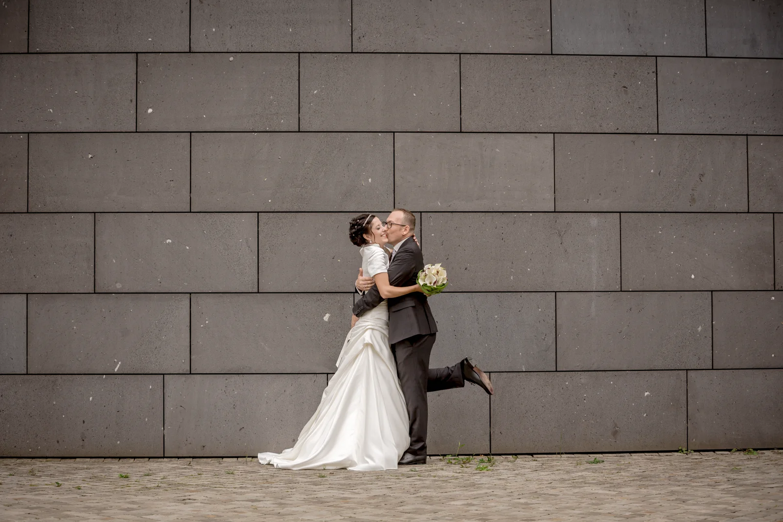 Ein Kuss vor der grauen Fassade – Hochzeit von Lydia und Christian in Erfurt