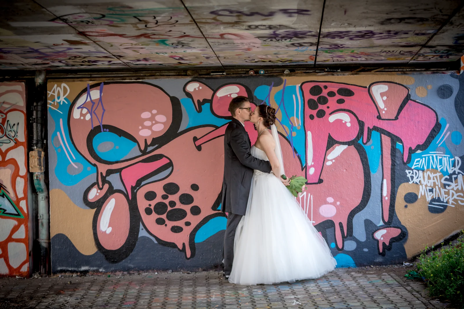 Das Brautpaar vor einer farbenfrohen Graffitiwand – Hochzeitsreportage von Matthias und Kerstin