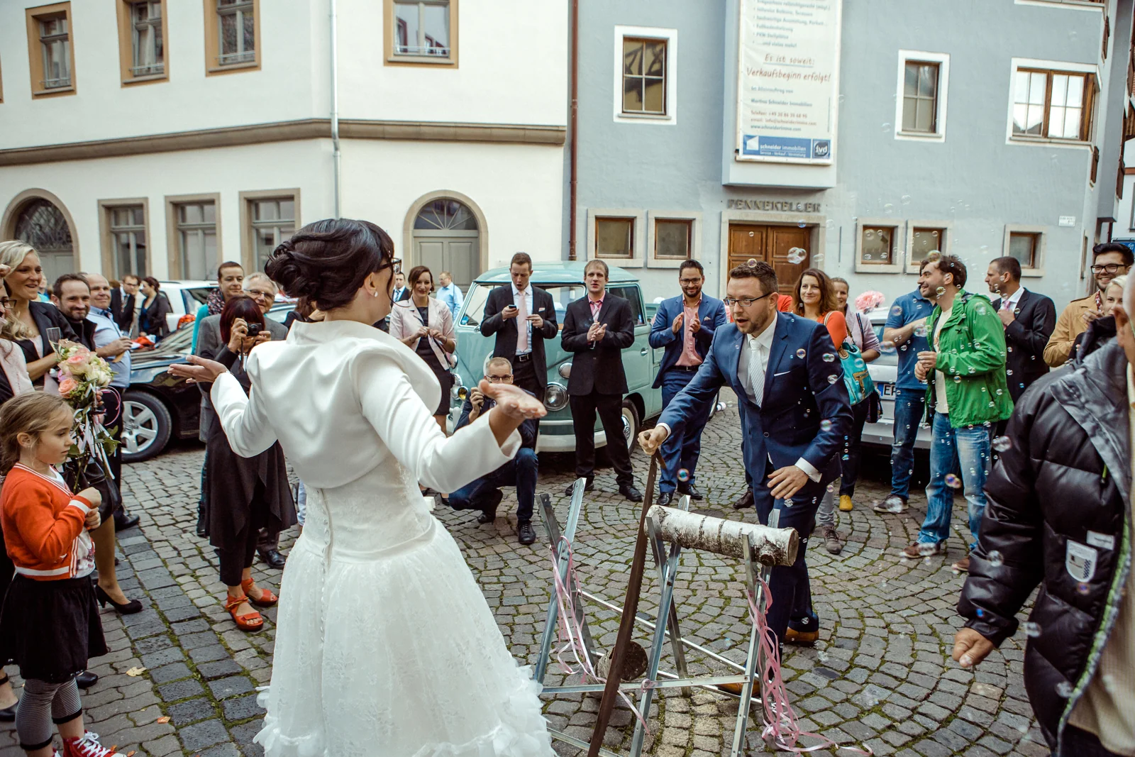 Die Gäste begleiten das Baumstammsägen – Hochzeitsreportage von Melanie und André