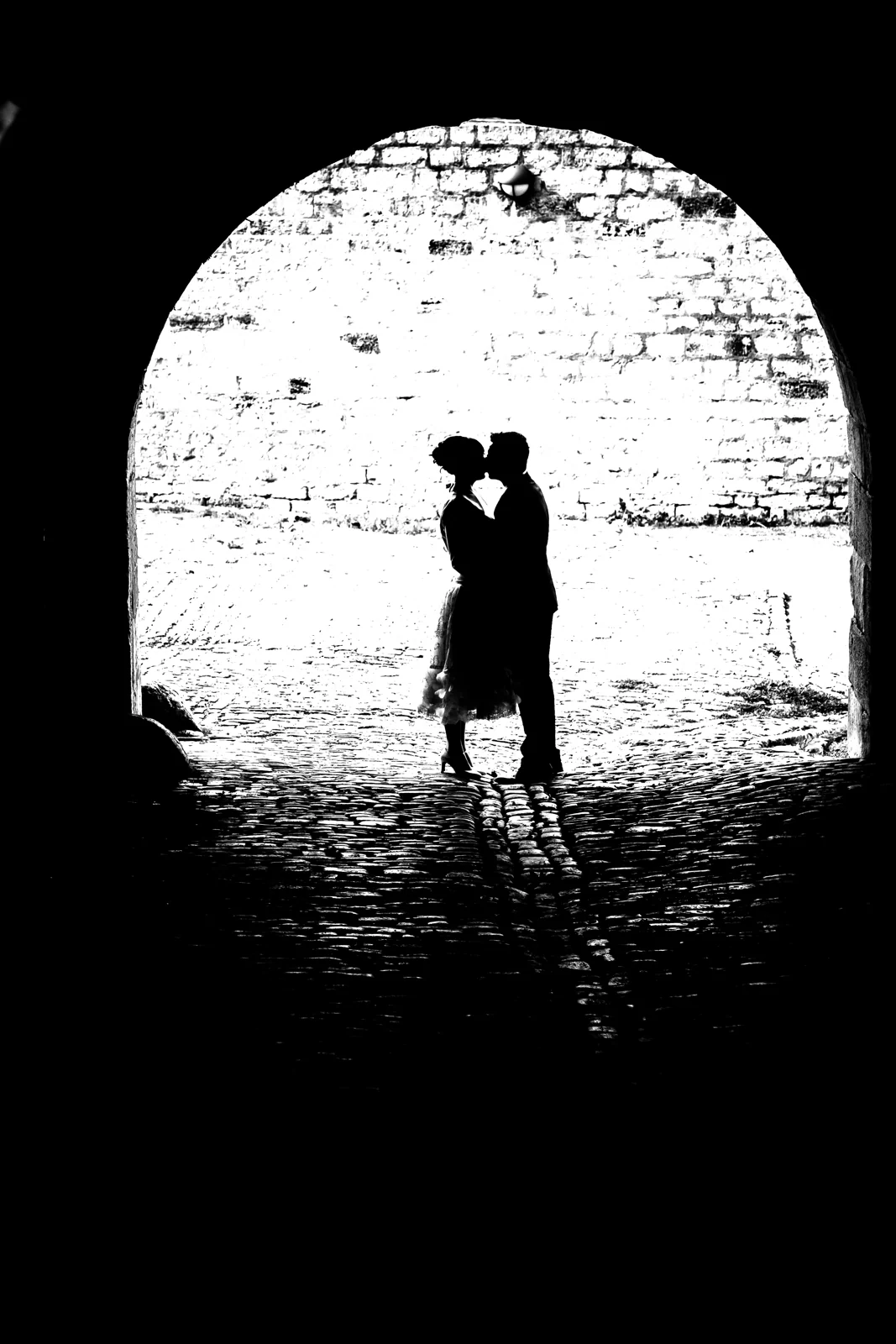 Das Brautpaar als Silhouette im Torbogen – Hochzeitsreportage von Melanie und André