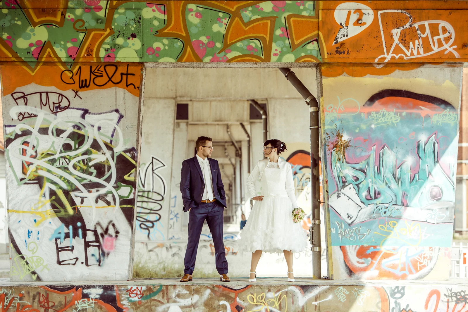 Melanie und André vor einer Graffitiwand – Hochzeitsreportage von Melanie und André