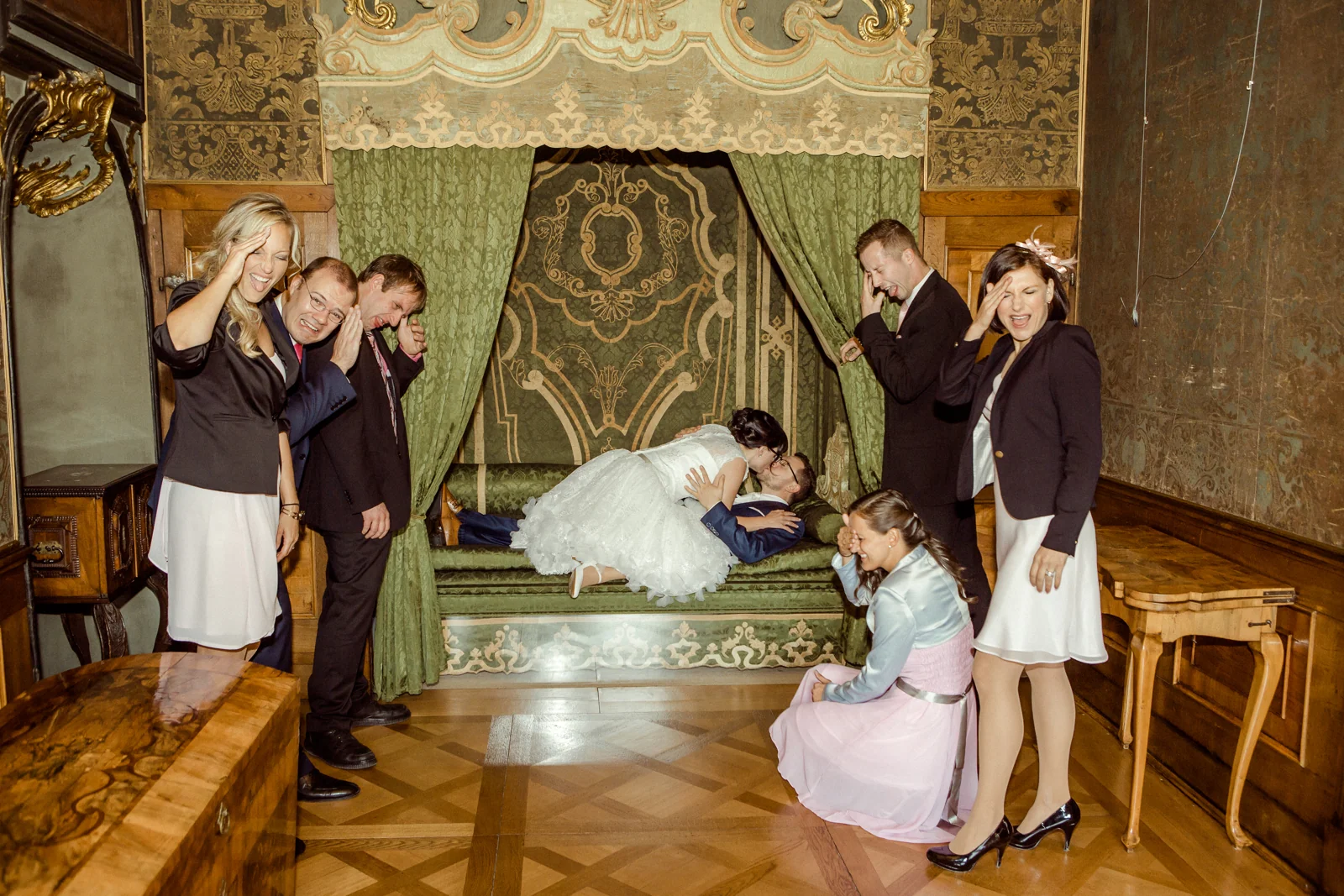 Ein ausgelassenes Gruppenbild vor dem Himmelbett – Hochzeitsreportage von Melanie und André