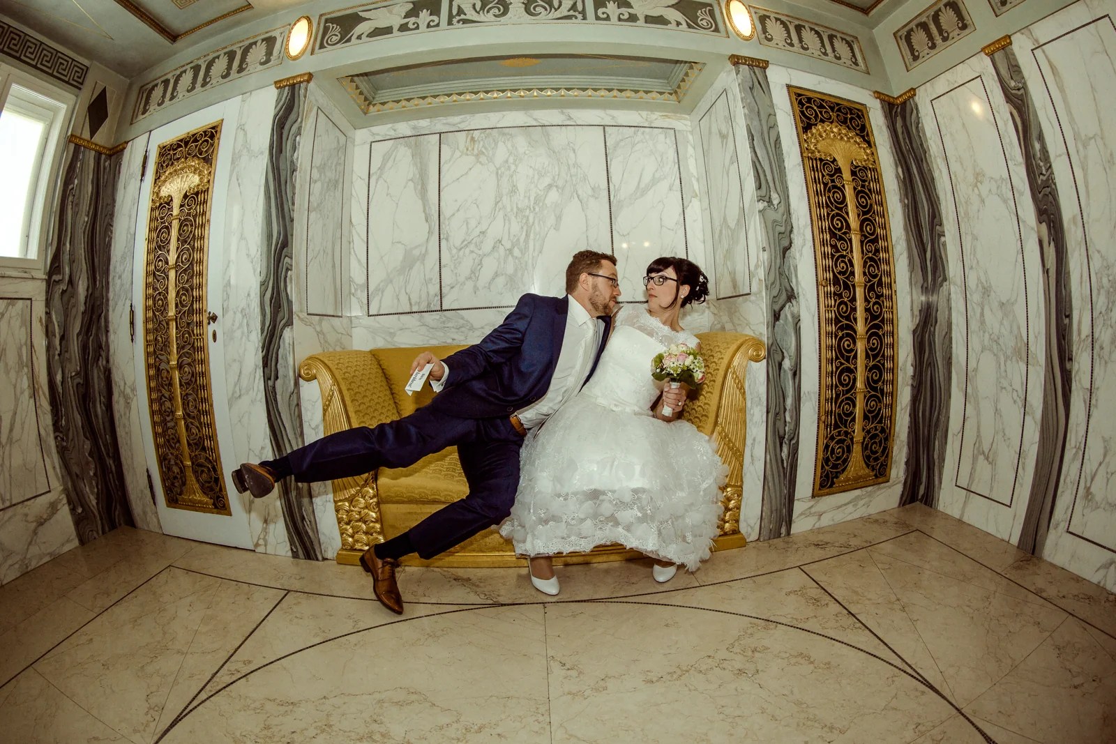 Ein spielerischer Paarmoment auf dem gelben Sofa – Hochzeitsreportage von Melanie und André