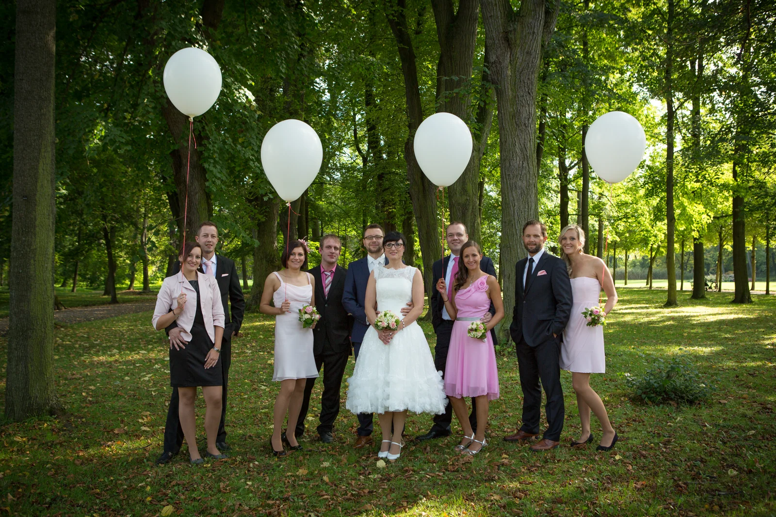 Das Brautpaar mit den Begleitern und weißen Luftballons – Hochzeitsreportage von Melanie und André