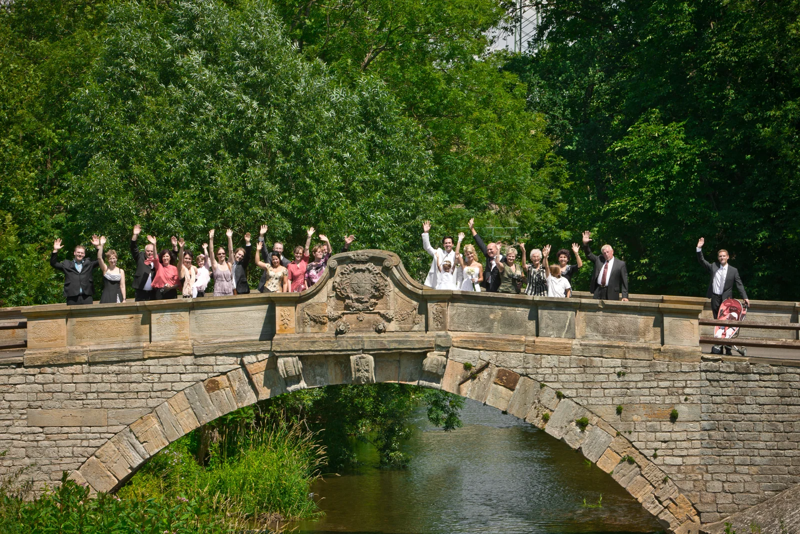 Die Gäste warten an der Brücke im Schlosspark – Hochzeitsreportage von Sandra und Lars