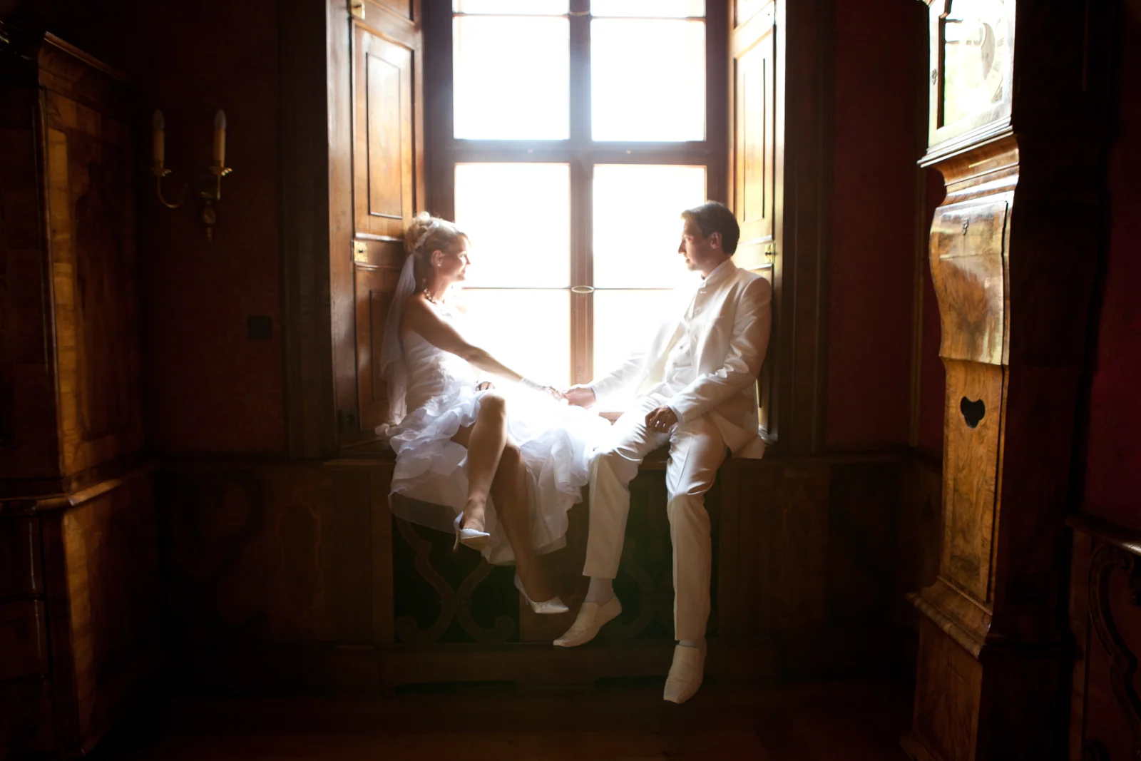 Hand in Hand am Fenster des Schlosses – Hochzeitsreportage von Sandra und Lars
