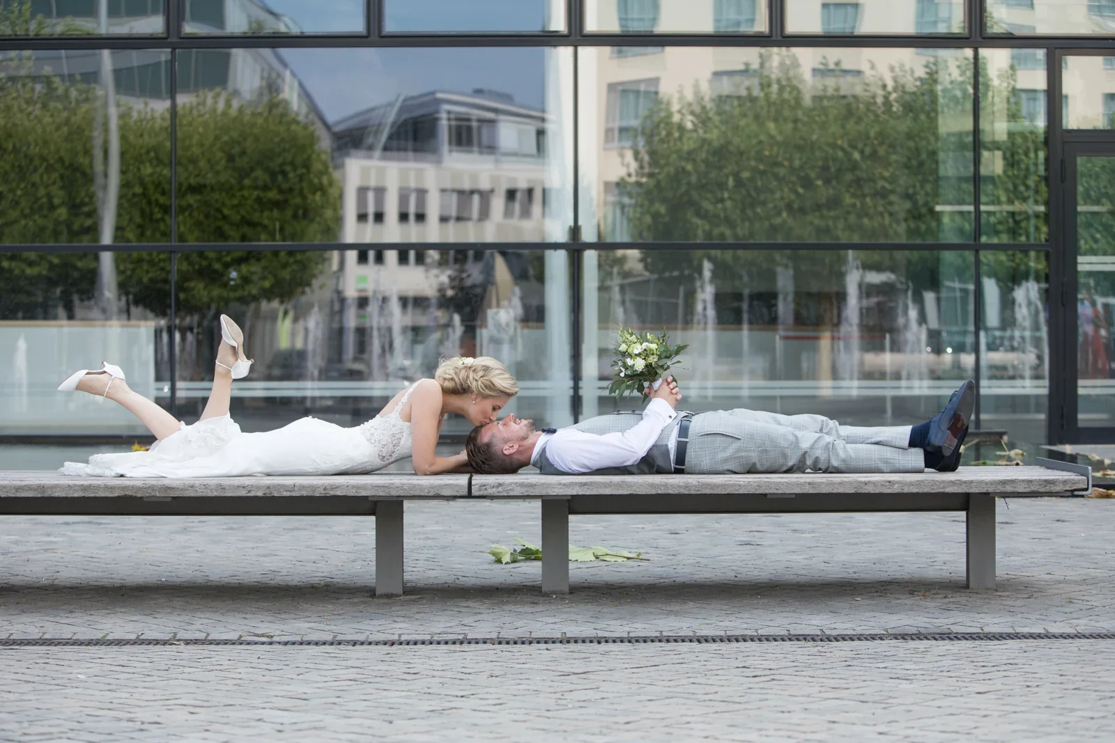 Kopf an Kopf auf der Bank vor dem Theater – Hochzeit von Anja und Toni in Erfurt