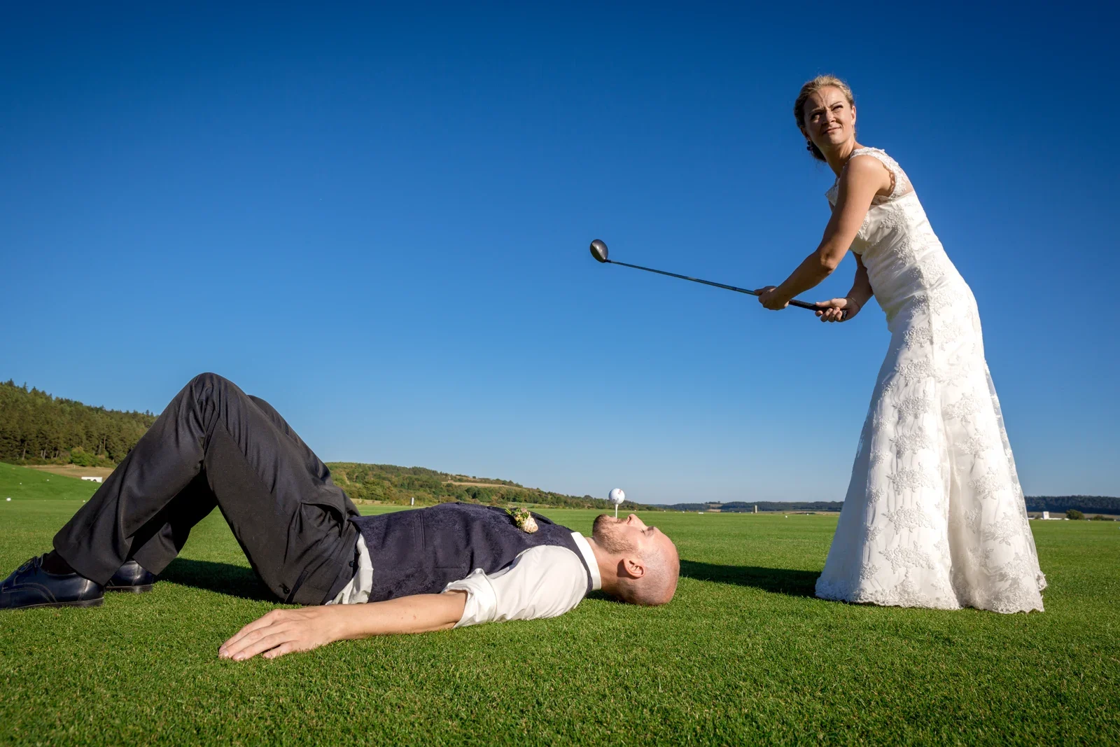 Eine spielerische Szene mit dem Golfschläger – Hochzeit von Caro und David auf Schloss Ettersburg und in Blankenhain