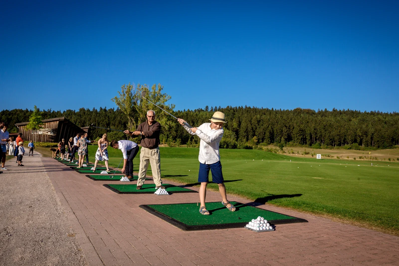 Die Gäste probieren sich beim Golfen – Hochzeit von Caro und David auf Schloss Ettersburg und in Blankenhain