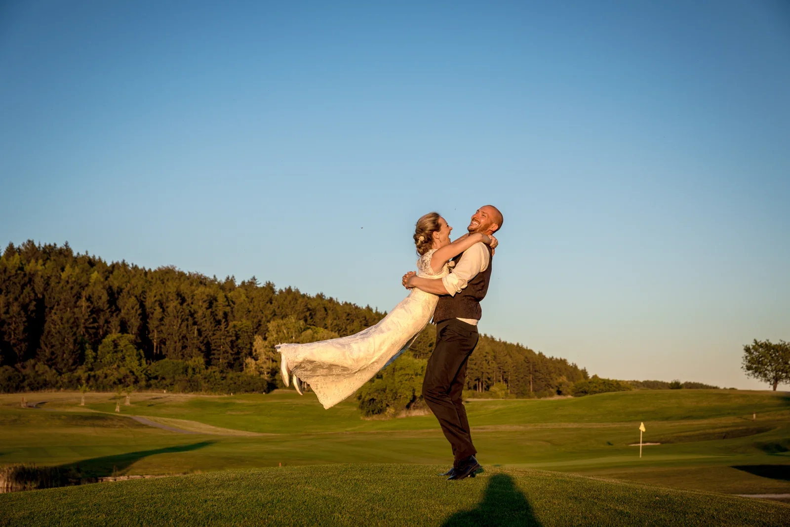 David trägt Caro über den Golfplatz – Hochzeit von Caro und David auf Schloss Ettersburg und in Blankenhain