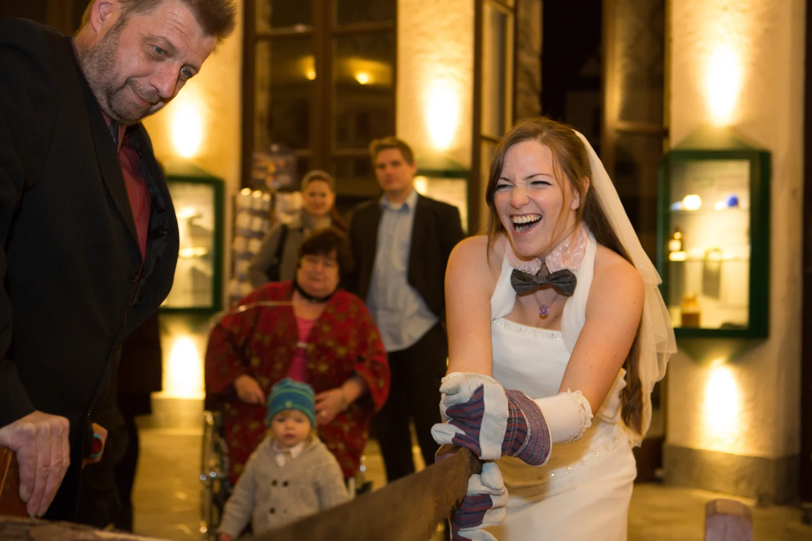 Christin lacht beim Baumstammsägen – Hochzeitsreportage von Christin und Alexander