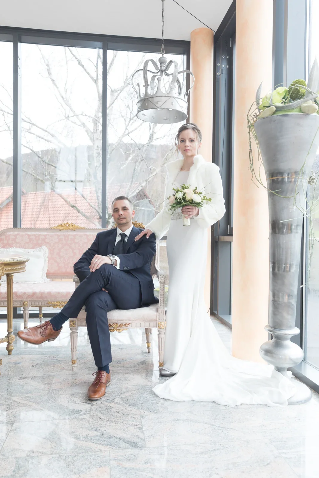 Olivia und Tobias zwischen den Sesseln im Wintergarten – Hochzeit von Olivia und Tobias in Friedewald