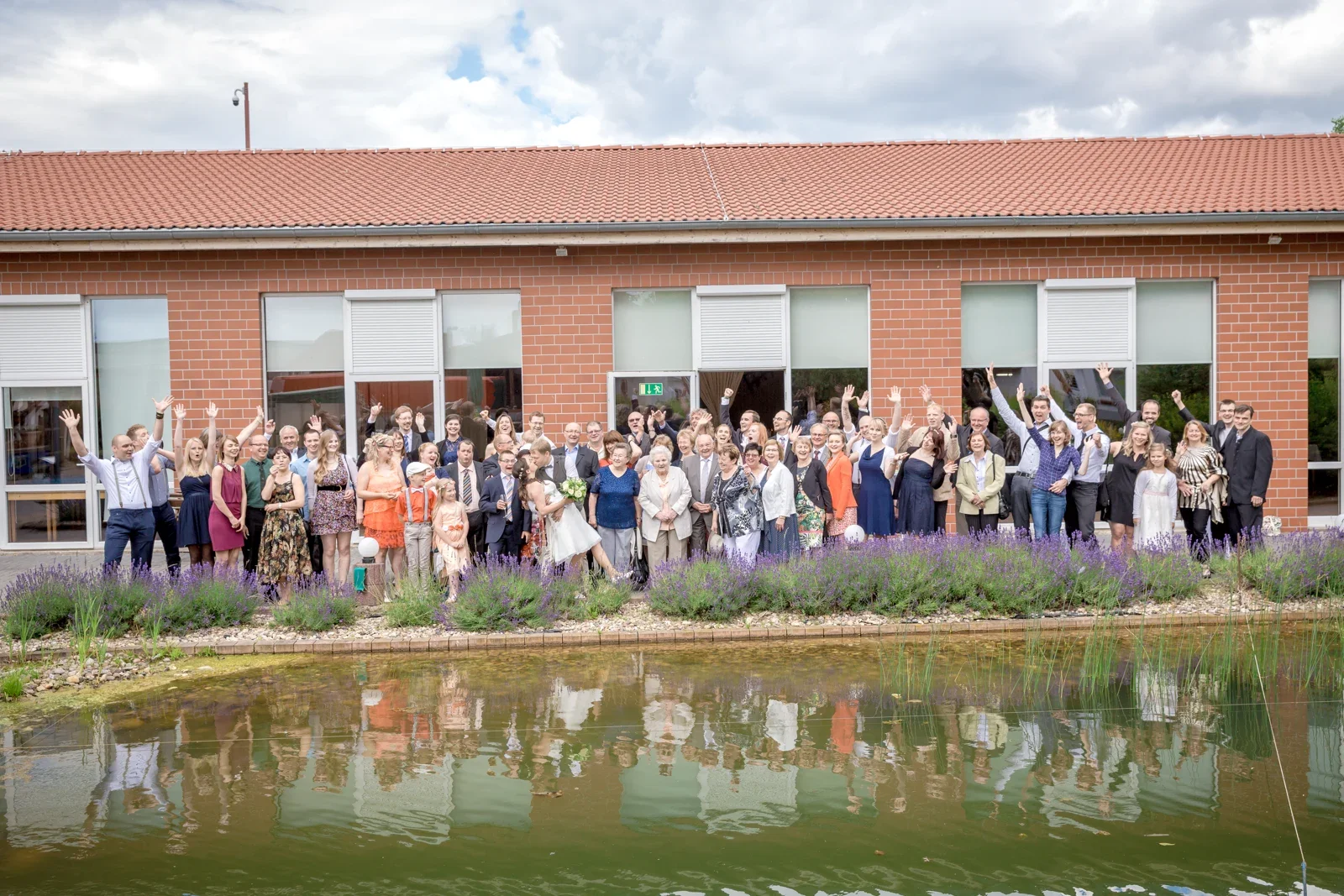 Alle zusammen für das Gruppenbild am Wasser – Hochzeit von Robert und Christina in Großpaschleben