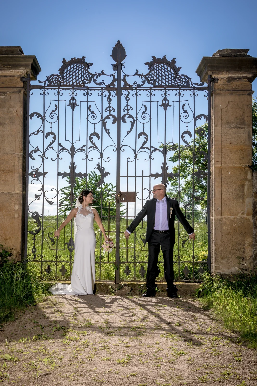 Das Brautpaar am schmiedeeisernen Tor – Hochzeit von Katja und Ulrick in Großrettbach