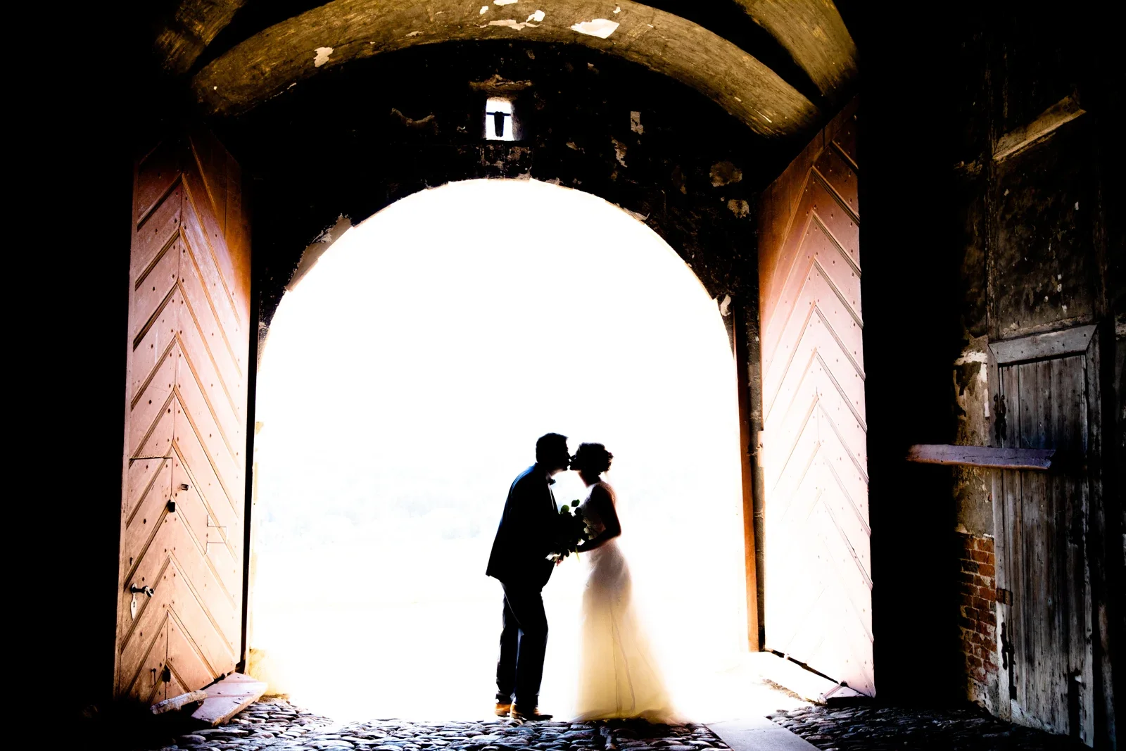 Ein Kuss als Silhouette im Torbogen – Hochzeit von Jessica und Leander in Tonna und Dachwig