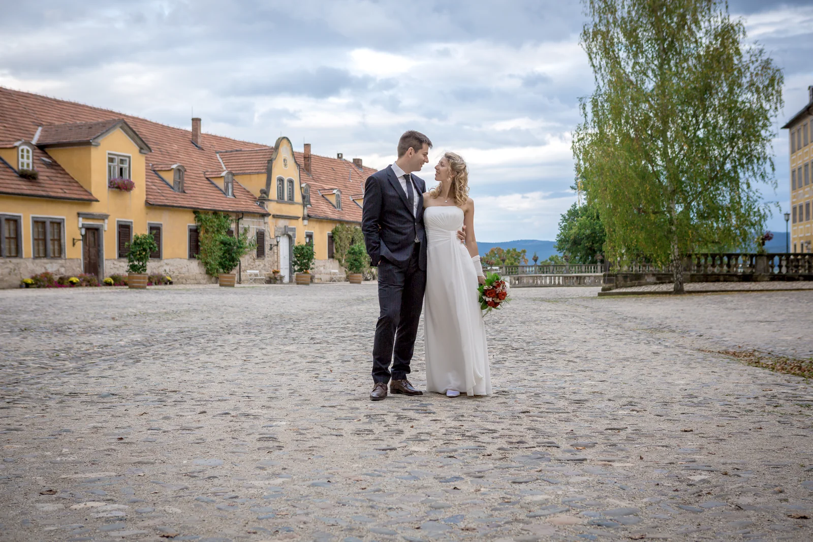 Das Brautpaar auf dem gepflasterten Platz – Hochzeitsreportage von Juliane und Tobias