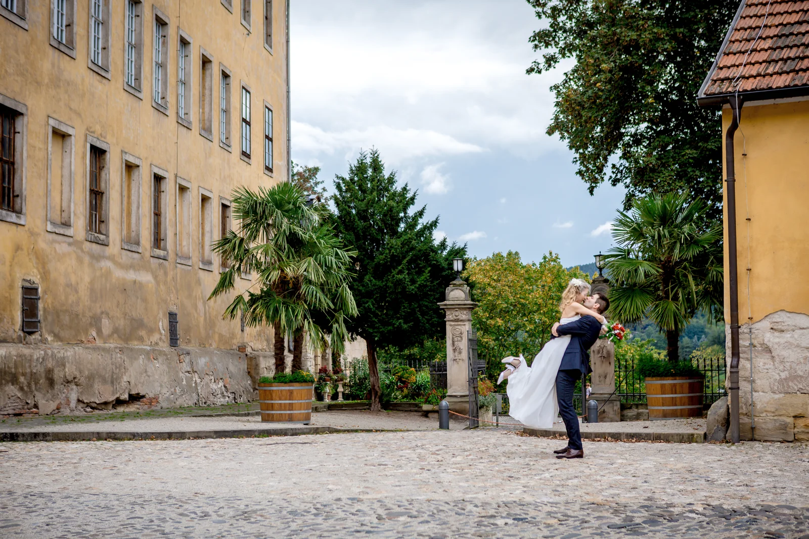 Tobias trägt Juliane vor der historischen Kulisse – Hochzeitsreportage von Juliane und Tobias