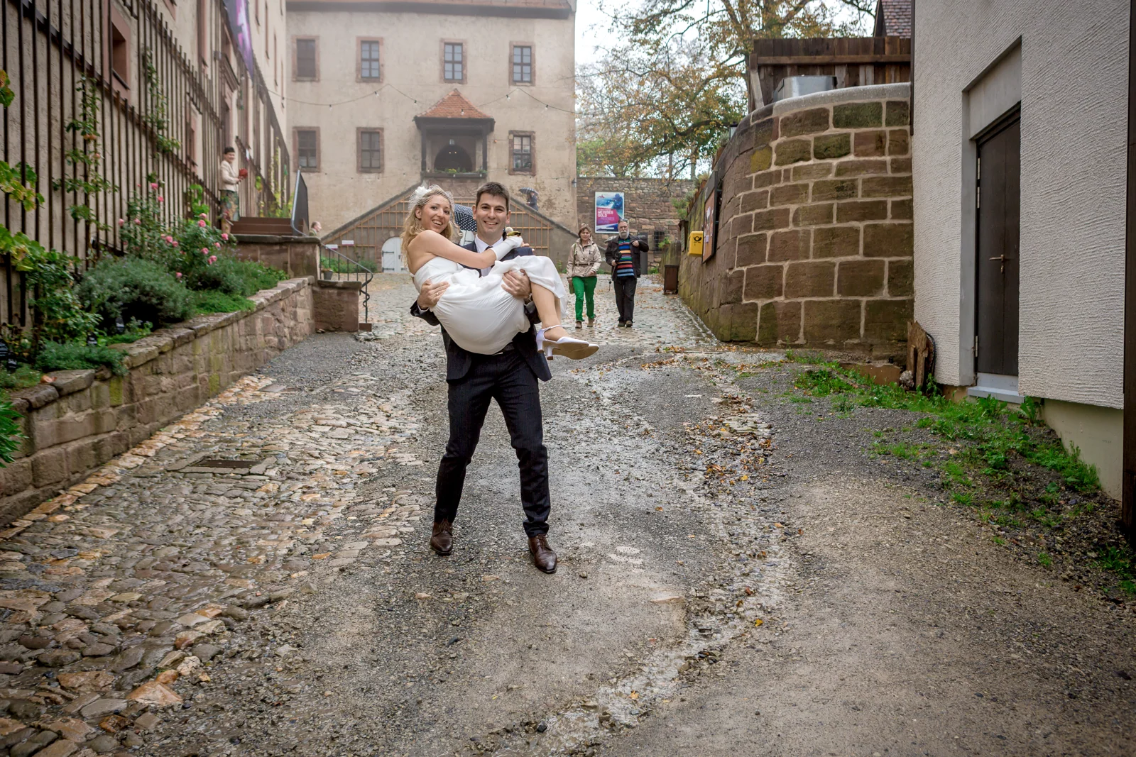 Tobias trägt Juliane durch die Gasse – Hochzeitsreportage von Juliane und Tobias