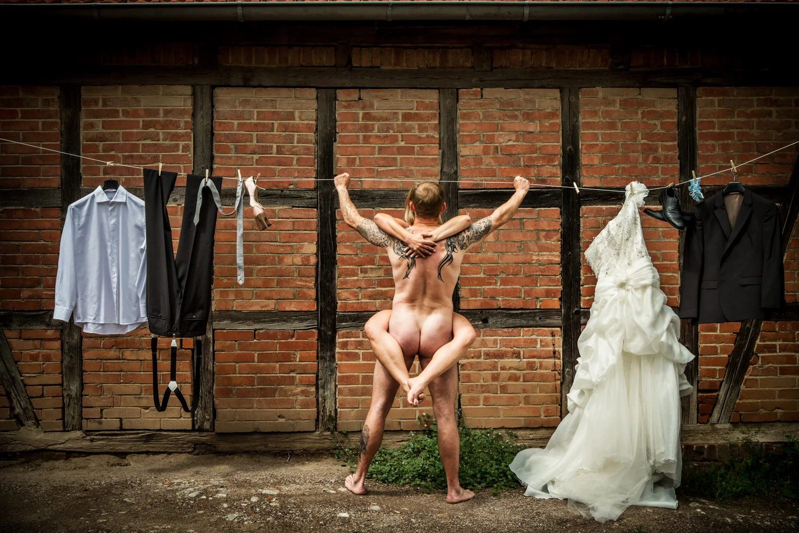 Ein augenzwinkerndes Schlussbild mit Brautkleid und Anzug an der Wäscheleine – Hochzeitsreportage von Delf Zeh
