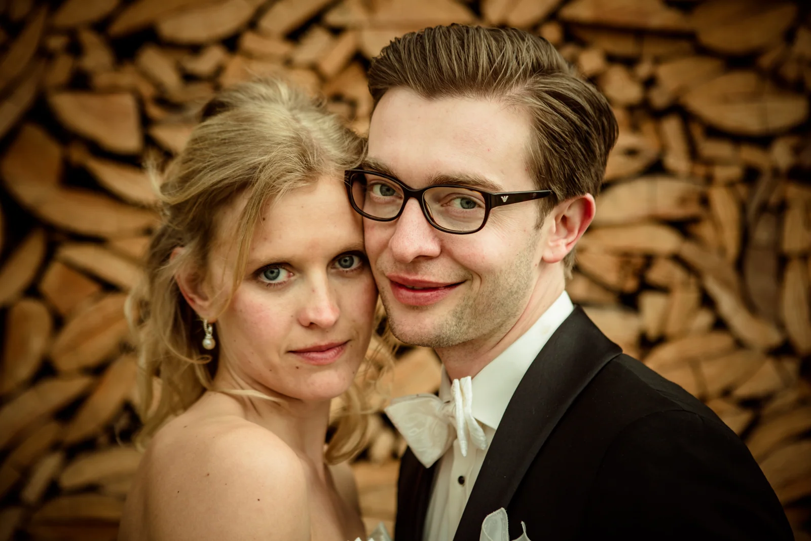 Ein gemeinsames Portrait vor der Holzwand – Hochzeitsreportage von Anne und Chris