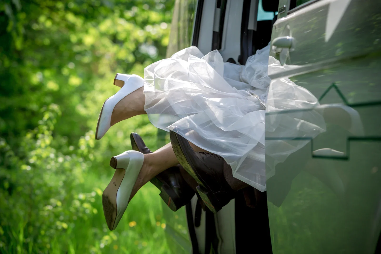 Brautkleid und Beine schauen aus dem Auto – Hochzeit und Taufe von Melanie und Andreas in Erfurt