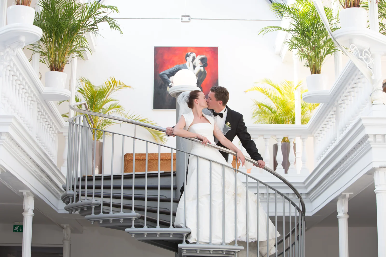 Ein Kuss auf der Treppe im Palmenhaus – Hochzeitsreportage von Steffen und Theresa