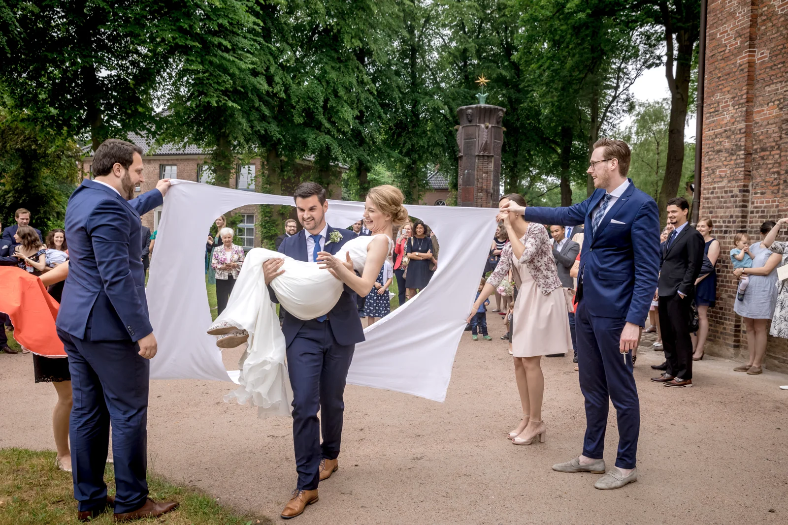 Martin trägt Hannah durch das ausgeschnittene Herz – Hochzeit von Hannah und Martin in Rellingen und Wedel