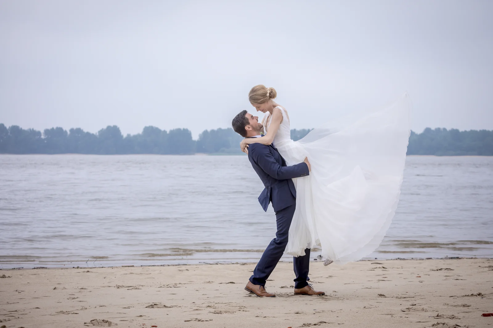 Martin hebt Hannah am Strand hoch – Hochzeit von Hannah und Martin in Rellingen und Wedel