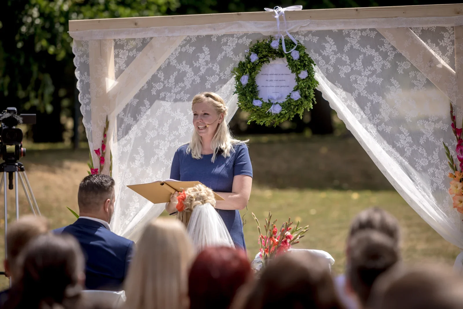 Die Traurednerin unter dem geschmückten Bogen – Hochzeit von Candi und Tippi in der Villa Bergfried in Saalfeld
