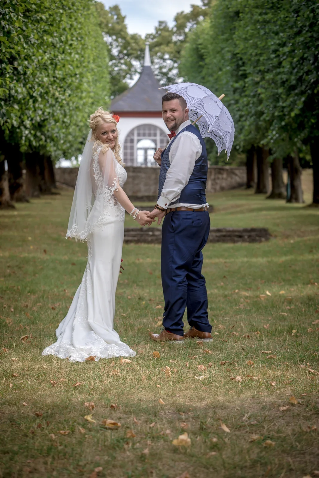 Das Brautpaar mit Spitzenschirm im Park – Hochzeit von Candi und Tippi in der Villa Bergfried in Saalfeld