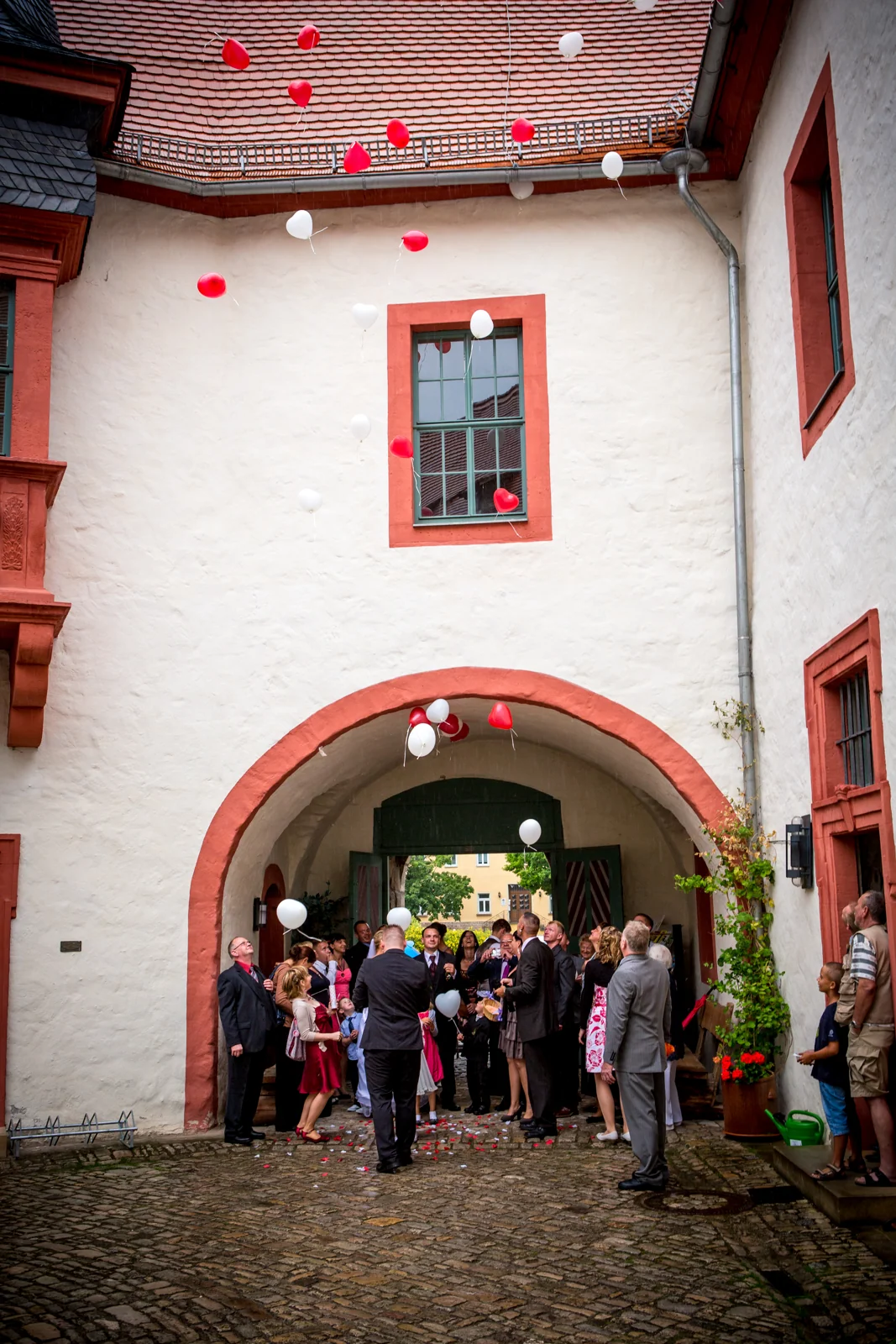 Luftballons steigen im Schlosshof auf – Hochzeitsreportage von Sandra und André